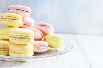 Obraz na płótnie Canvas Yellow and pink macaroons on white wooden background.