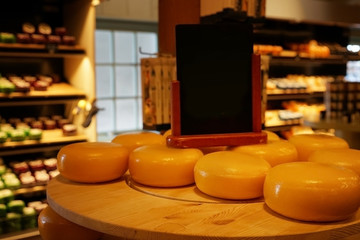 Wheels of cheese on wooden table in store