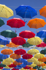 Opened colorful umbrellas with a part of blue sky floating in the air
