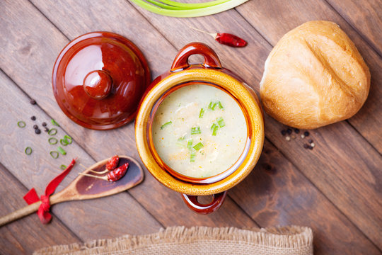 Cheese soup, bread bun and wooden spoon 