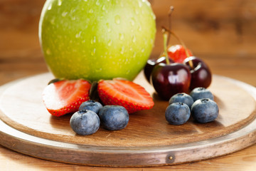 Fresh fruits on a wooden cutting board 