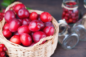 Plums in a basket, rowanberry and glass jars 