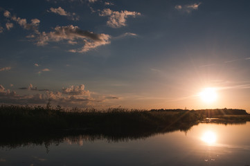 Fototapeta premium The setting sun over the water