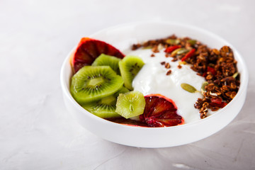 Granola,yogurt with kiwi and red oranges.Breakfast useful.Concept of Healthy Food. selective focus.