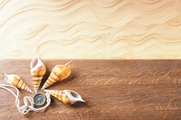 Composition with wooden board, sea shells and compass on sand. Concept of travel and vacation