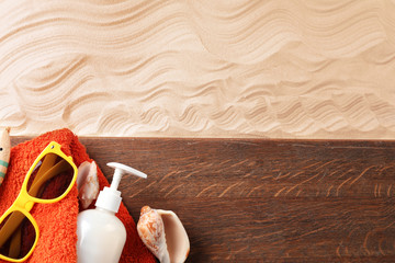 Composition with wooden board and beach accessories on sand. Concept of travel and vacation
