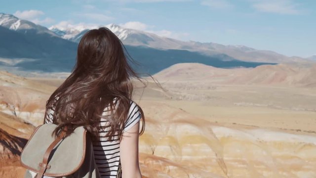 Close up portrait of beautiful young woman in nature with brunette hair blowing in wind looking at mountain view Hiker Girl in Norway Slow Motion.