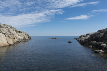 Fototapeta na wymiar The deep blue sea between two rocks on an island of Sweden