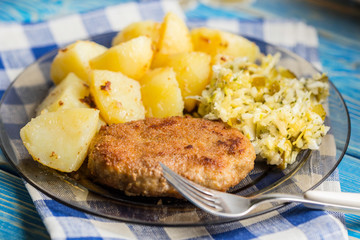 Fried pork chop with boiled potatoes and salad.