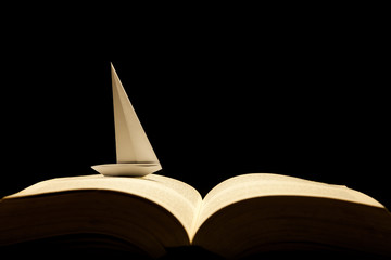 Barco de papel navegando por libro