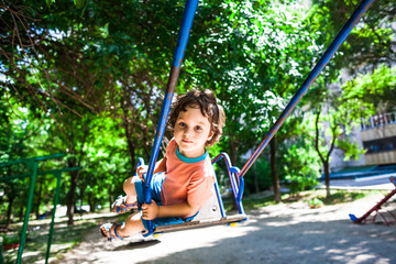 child is having fun on the swing.