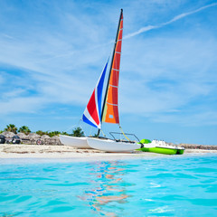 Naklejka premium The beautiful beach of Varadero in Cuba with a colorful sailboat