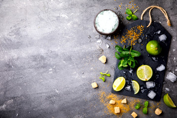  Ingredients for making Mojito Cocktail on a slate board.Mint, lime,cane sugar, ice.Cold Drink .Copy space for Text.selective focus.