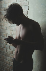 athlete macho with naked torso in trunks using mobile phone