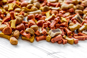 dry dog food in bulk on wooden background close up