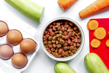 Set of animal dry food, vegetables and eggs on kitchen top view