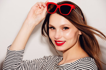 High fashion look.glamor stylish beautiful young happy smiling woman model with red lips and red sunglasses
