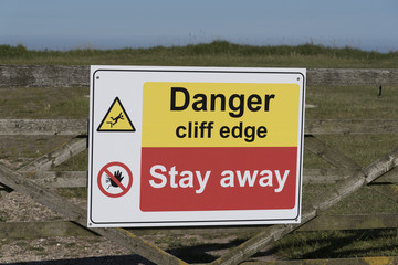 Danger signs on the cliff edge at Peveril Point in Swanage Bay Dorest England UK