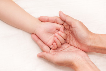 Baby life in mother hand. Mom take care of baby. Hand of baby in hands of parents. 