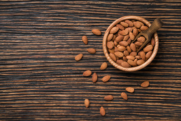 almonds nuts on a brown wooden table,top view