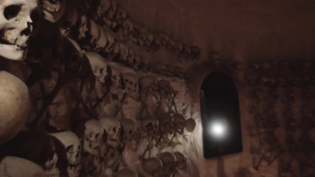 Woman exploring crypt of human bones inside church, Lampa, Peru. 4k	