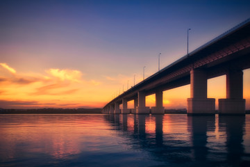 Naklejka na ściany i meble Bridge over the river at sunset
