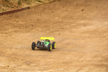 Radio controlled car model in race on dirt track