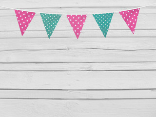 Birthday or baby shower mockup scene. String of pink and mint dotted fabric flags. Party decoration. Old white wooden background, empty space. Top view.
