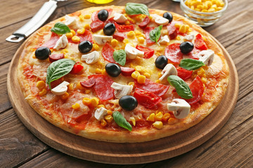 Plate with tasty pizza on wooden table