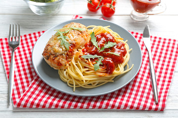 Delicious pasta with chicken parmesan and sauce on plate