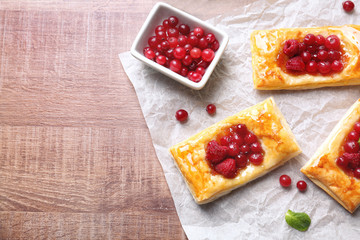 Food paper with delicious pastries on wooden table