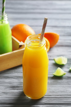 Bottle of delicious juice on wooden background