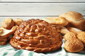 Baked round loaf and variety of bread on table
