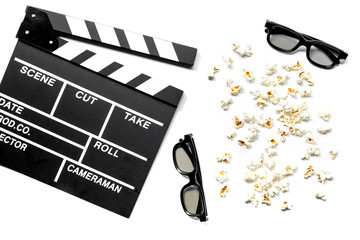 Watching the film. Movie clapperboard, sunglasses and popcorn on white background top view