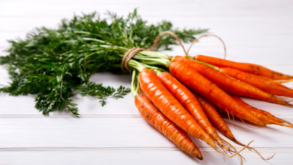 Bunch of fresh carrots with green leaves on a White Background. Vegetable.Food or Healthy diet concept.Vegetarian.Copy space for Text. selective focus.