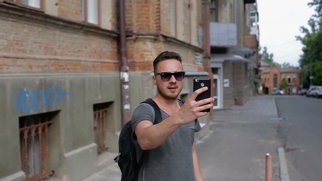 Tourist makes selfie in front of beautiful old houses