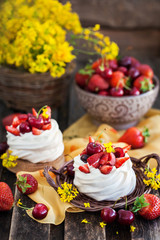 Obraz na płótnie Canvas Delicious mini Pavlova meringue cake decorated with fresh berries