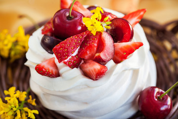 Delicious mini Pavlova meringue cake decorated with fresh berries