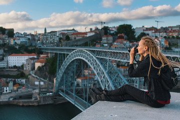 Young woman taking pictures in the downtown of Porto, Portugal.