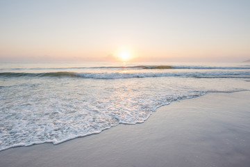 Prachtige zonsondergang en zachte golf op het ondiepe strand