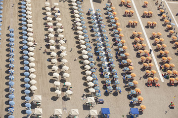 Top view of rows of umbrellas on a sandy beach in Viareggio, Italy