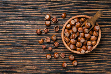 Hazelnut with peeled hazelnuts on a brown wooden table,top view