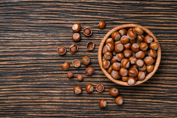 Hazelnut with peeled hazelnuts on a brown wooden table,top view