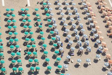 Top view of rows of umbrellas on a sandy beach in Viareggio, Italy