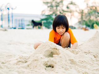 happy kid enjoy with making sand castle and mountain at tropical beach