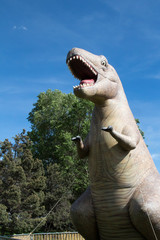 Inflatable Tyrannosaurus Rex towering over a tree