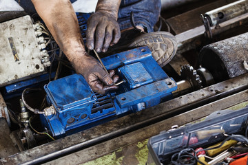 Hand holding hexagonal wrench and during maintenance work of electric motor