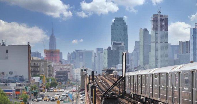 A view of the Manhattan skyline as seen from an elevated subway platform over Queens Boulevard in Queens.  