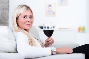 Junge Frau entspannt sich bei einem Glas Wein
