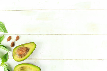Ripe avocado with leaves on a white background